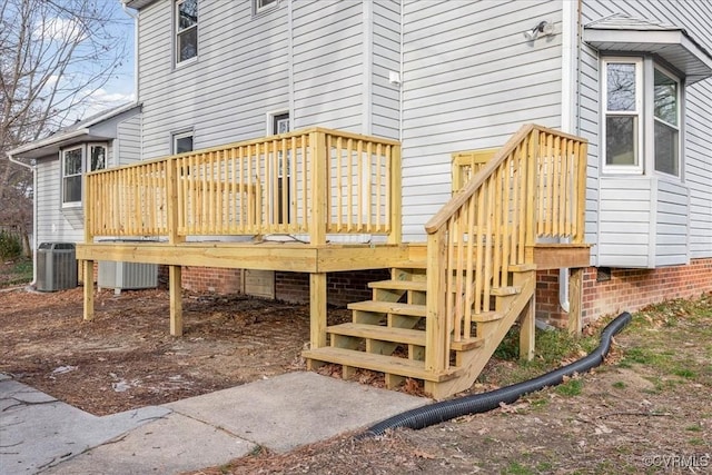 wooden deck featuring central AC unit and stairway