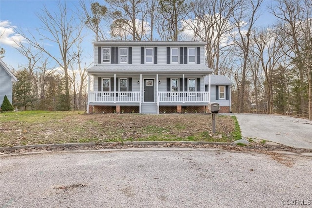 colonial house featuring a porch and aphalt driveway