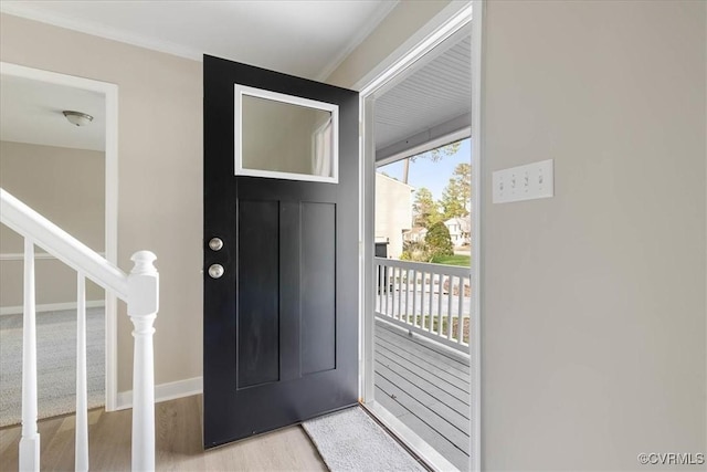 entryway with stairs, baseboards, and wood finished floors