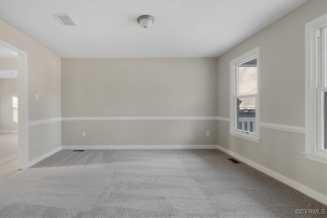 carpeted empty room featuring visible vents and baseboards