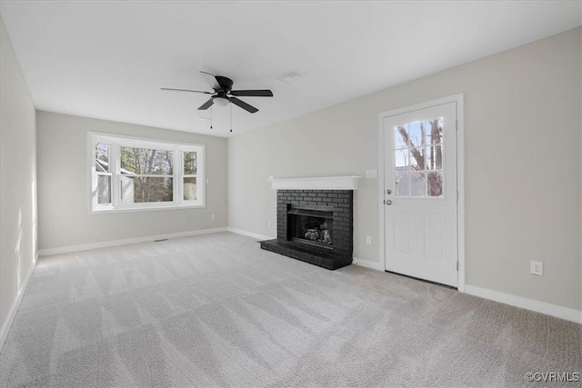 unfurnished living room with carpet, a fireplace, and a wealth of natural light