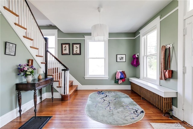 foyer entrance featuring stairs, wood finished floors, and baseboards