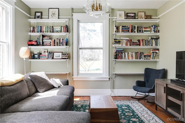 sitting room featuring baseboards, a notable chandelier, and wood finished floors