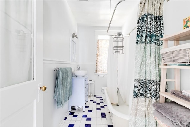 full bathroom with tile patterned floors, toilet, a shower with shower curtain, and a sink