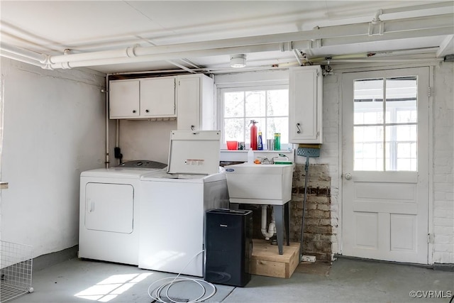 clothes washing area with a sink, cabinet space, and washing machine and dryer