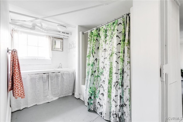 bathroom featuring a sink, finished concrete flooring, and shower / bathtub combination with curtain