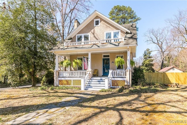 view of front of property featuring a porch, a chimney, and fence