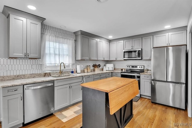 kitchen with stainless steel appliances, gray cabinets, and a sink