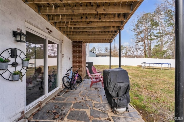 view of patio / terrace with a fenced backyard, a trampoline, and area for grilling