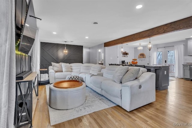 living room with light wood-style floors, beam ceiling, and recessed lighting