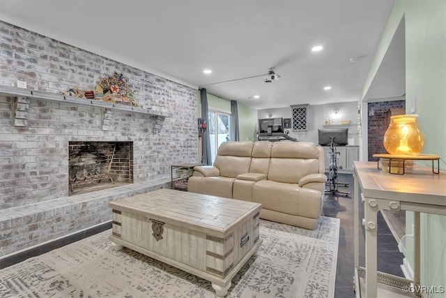 living area featuring recessed lighting, a fireplace, and brick wall