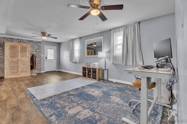 office area with brick wall, wood finished floors, and baseboards