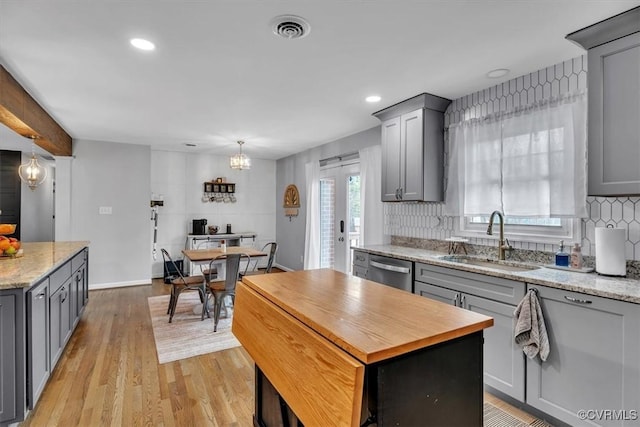 kitchen featuring a kitchen island, visible vents, a sink, and gray cabinetry