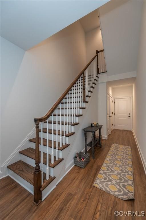 stairway with baseboards and wood finished floors