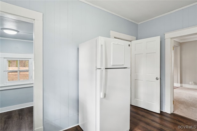 kitchen with baseboards, dark wood-style flooring, freestanding refrigerator, and crown molding