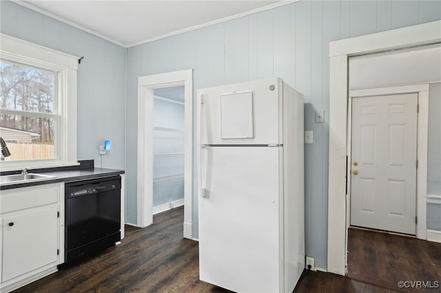 kitchen with black dishwasher, dark wood-style floors, freestanding refrigerator, white cabinetry, and a sink