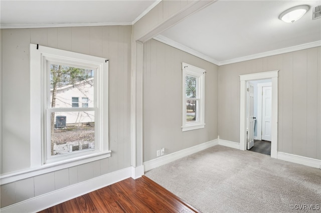 unfurnished room with baseboards, dark carpet, visible vents, and crown molding