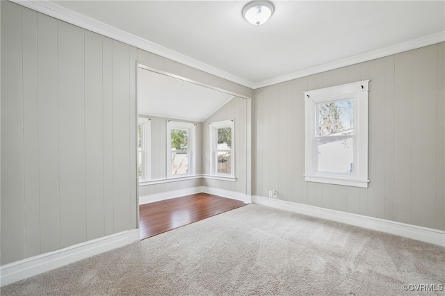 unfurnished room with ornamental molding, carpet, vaulted ceiling, and baseboards