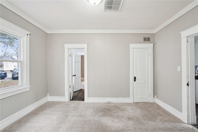 unfurnished bedroom featuring visible vents, carpet flooring, and ornamental molding