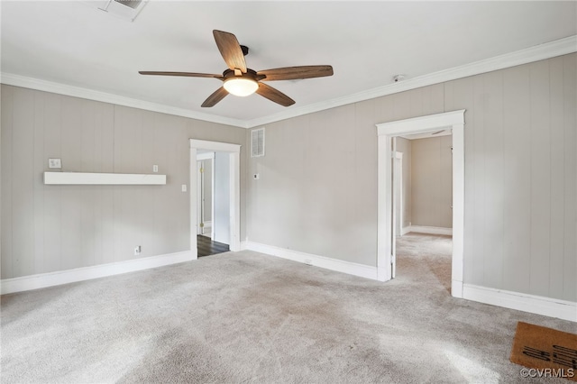 carpeted empty room with visible vents, ornamental molding, ceiling fan, and baseboards