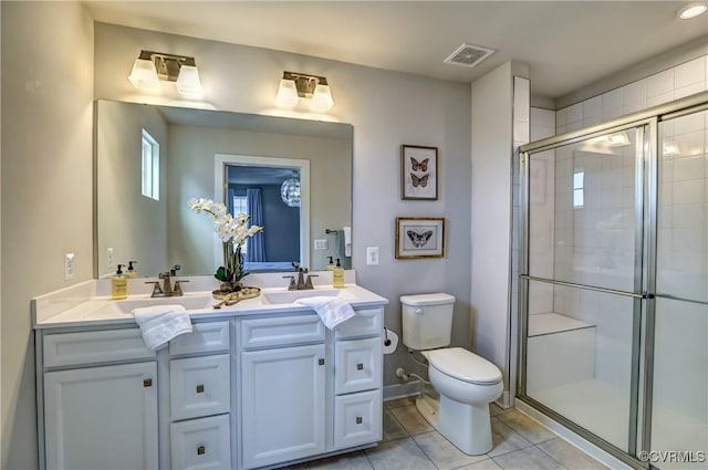 bathroom featuring tile patterned flooring, toilet, a sink, visible vents, and tiled shower