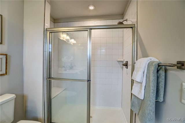 bathroom with a shower stall and toilet