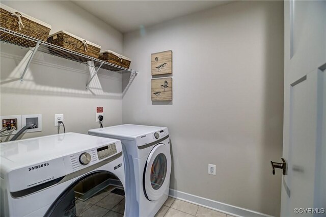 washroom with laundry area, light tile patterned floors, baseboards, and separate washer and dryer