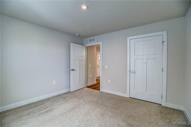 unfurnished bedroom featuring baseboards, visible vents, and carpet flooring