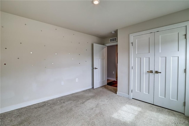 unfurnished bedroom with light carpet, a closet, visible vents, and baseboards