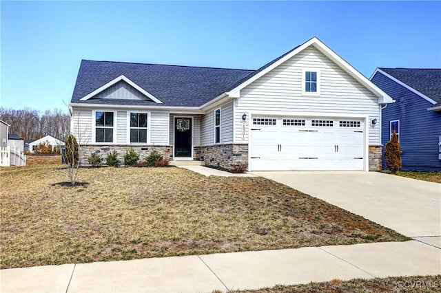 view of front facade with driveway, a garage, a shingled roof, stone siding, and a front yard