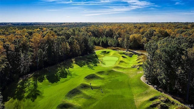 bird's eye view featuring view of golf course and a forest view