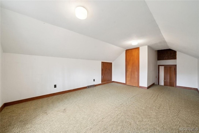 bonus room with visible vents, baseboards, lofted ceiling, and light carpet