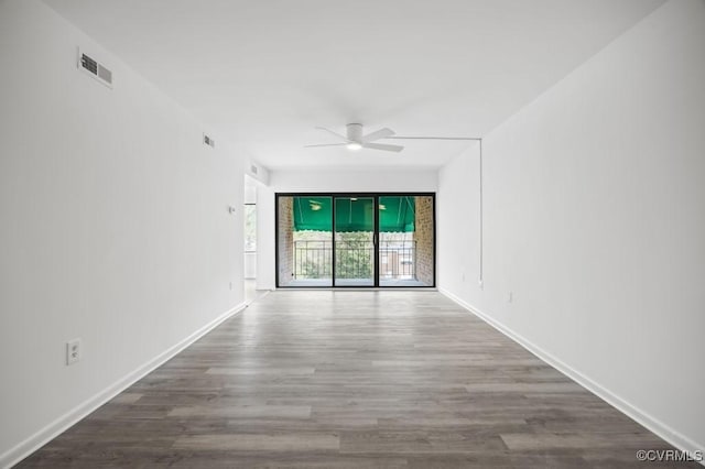 empty room featuring visible vents, baseboards, wood finished floors, and a ceiling fan