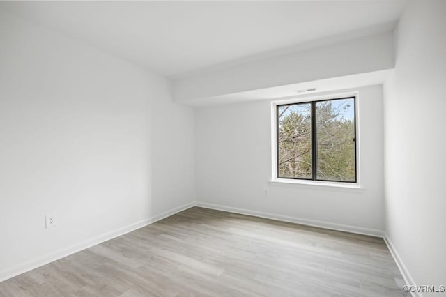 unfurnished room featuring baseboards and light wood-style flooring