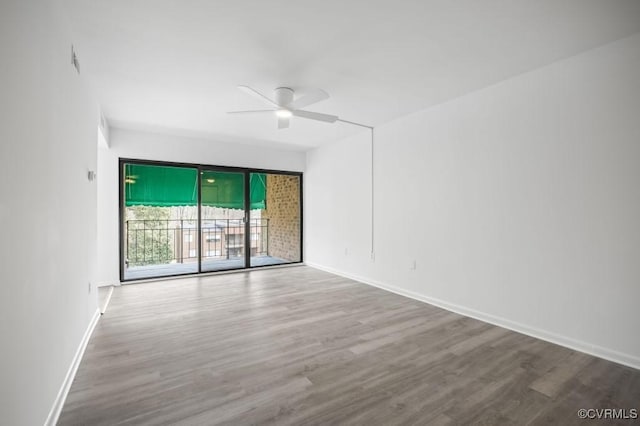 unfurnished room featuring a ceiling fan, wood finished floors, and baseboards