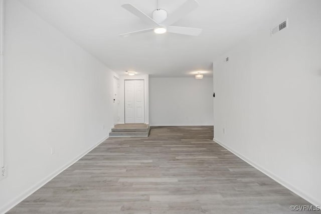 spare room with visible vents, baseboards, ceiling fan, and wood finished floors