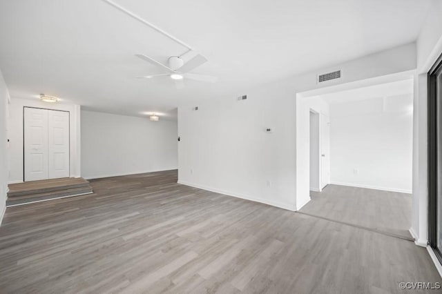 empty room featuring visible vents, baseboards, ceiling fan, and wood finished floors