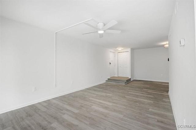 unfurnished room with ceiling fan, baseboards, and wood finished floors