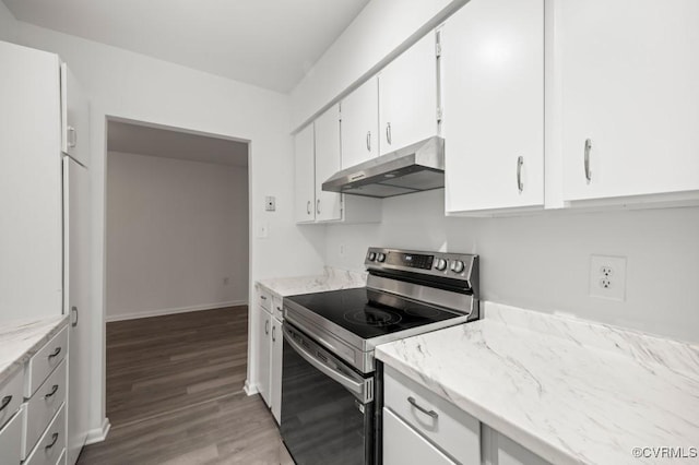 kitchen featuring under cabinet range hood, wood finished floors, white cabinetry, stainless steel range with electric cooktop, and baseboards