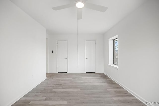 unfurnished bedroom featuring wood finished floors, baseboards, and ceiling fan