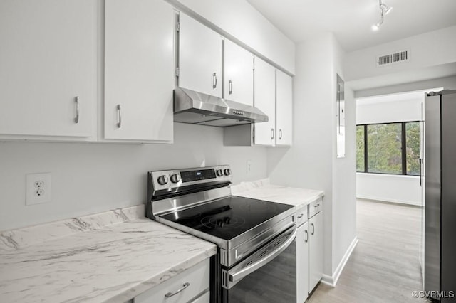 kitchen with visible vents, under cabinet range hood, light wood-type flooring, appliances with stainless steel finishes, and white cabinetry