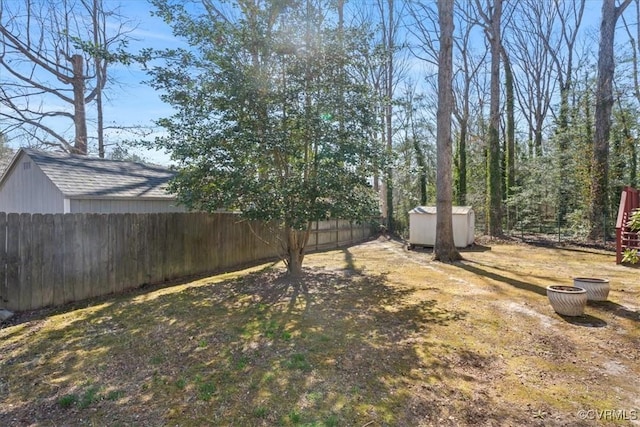 view of yard featuring a fenced backyard, an outdoor structure, and a shed