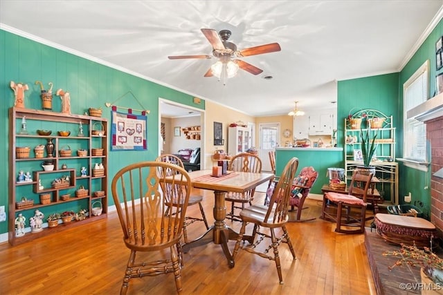 dining area with crown molding, ceiling fan, and wood-type flooring