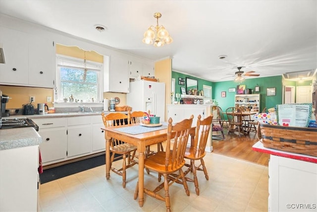 dining room with visible vents, ceiling fan with notable chandelier, and light floors