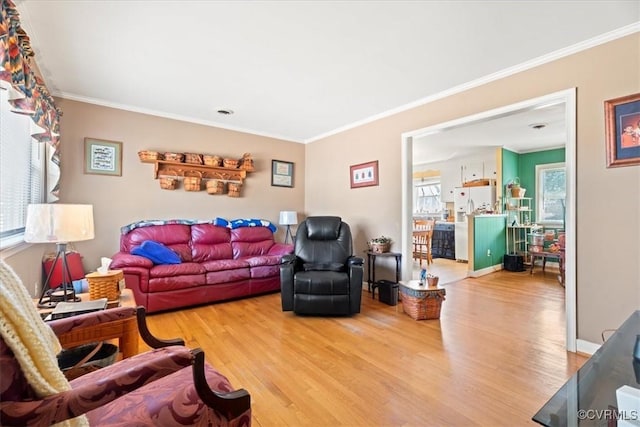 living room with ornamental molding and light wood finished floors