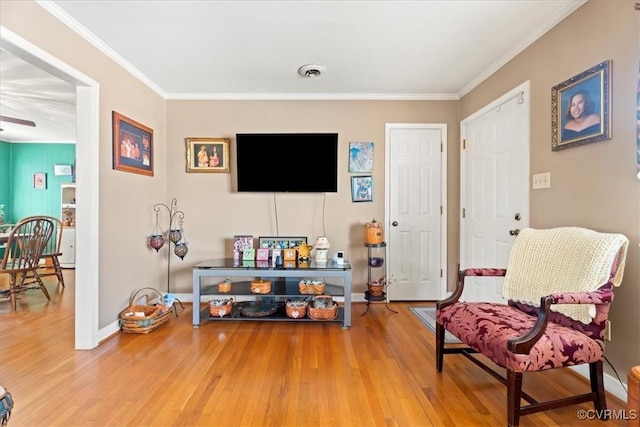 sitting room with visible vents, ornamental molding, baseboards, and wood finished floors