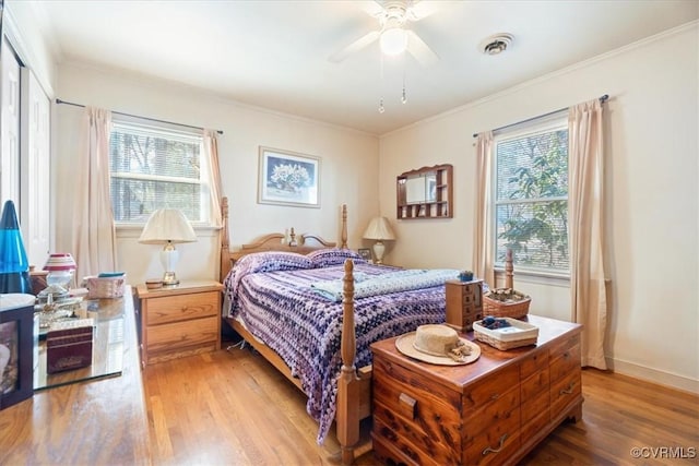 bedroom with visible vents, light wood finished floors, and ornamental molding