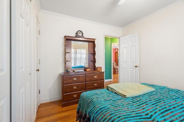 bedroom featuring baseboards, light wood-style floors, ornamental molding, and a ceiling fan