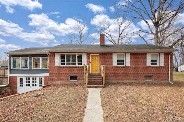 view of front of home featuring brick siding, entry steps, and a chimney