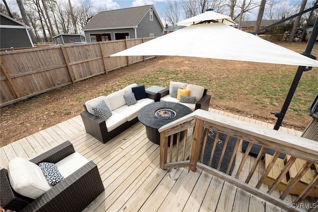 deck featuring an outdoor living space with a fire pit and fence